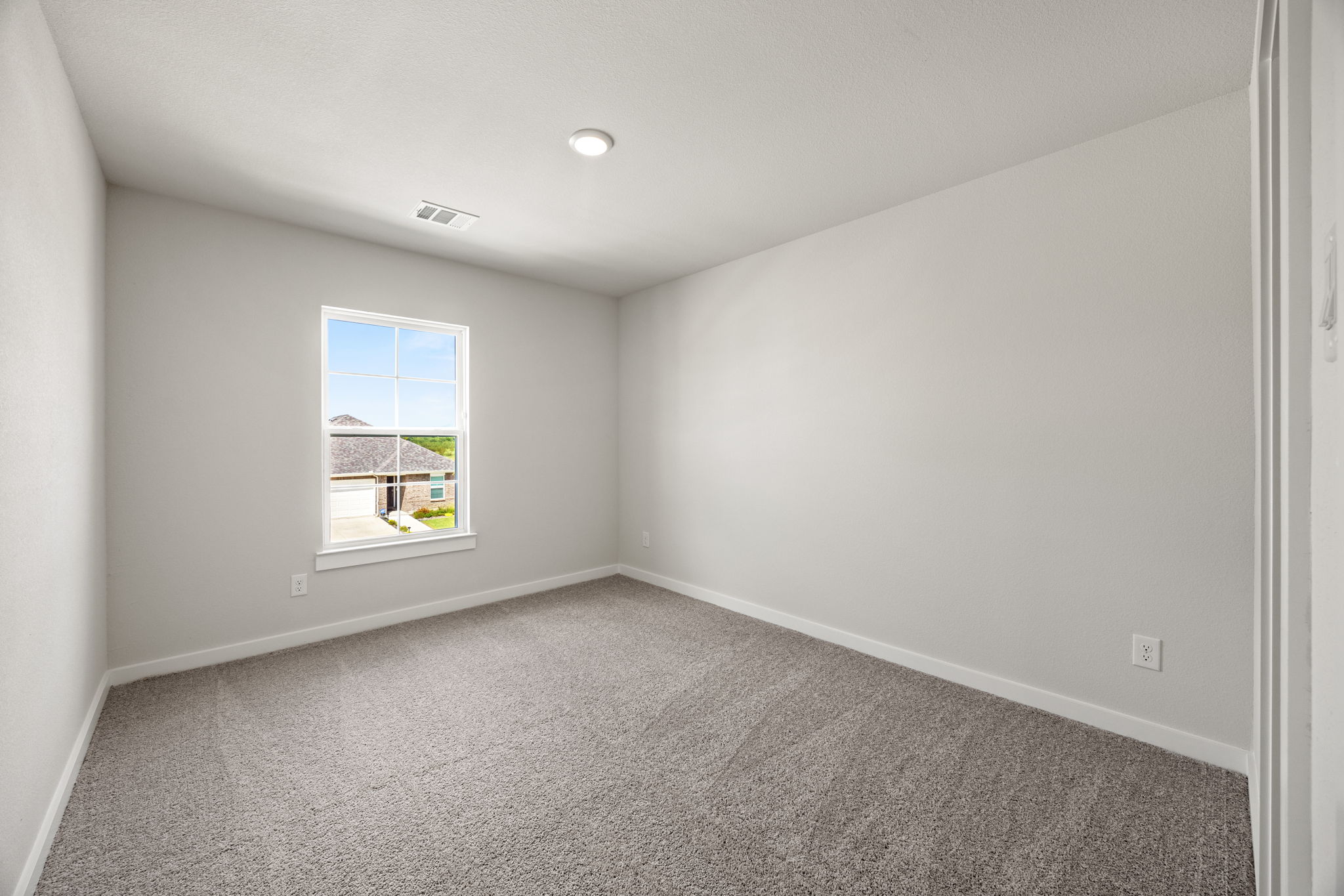 A room with a window and carpet.