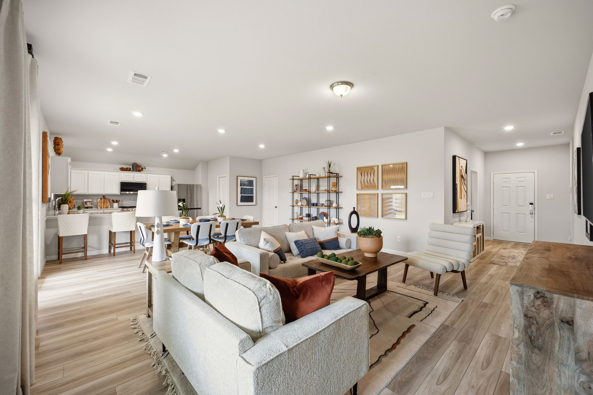 A large living room with a large white couch and a wood floor.