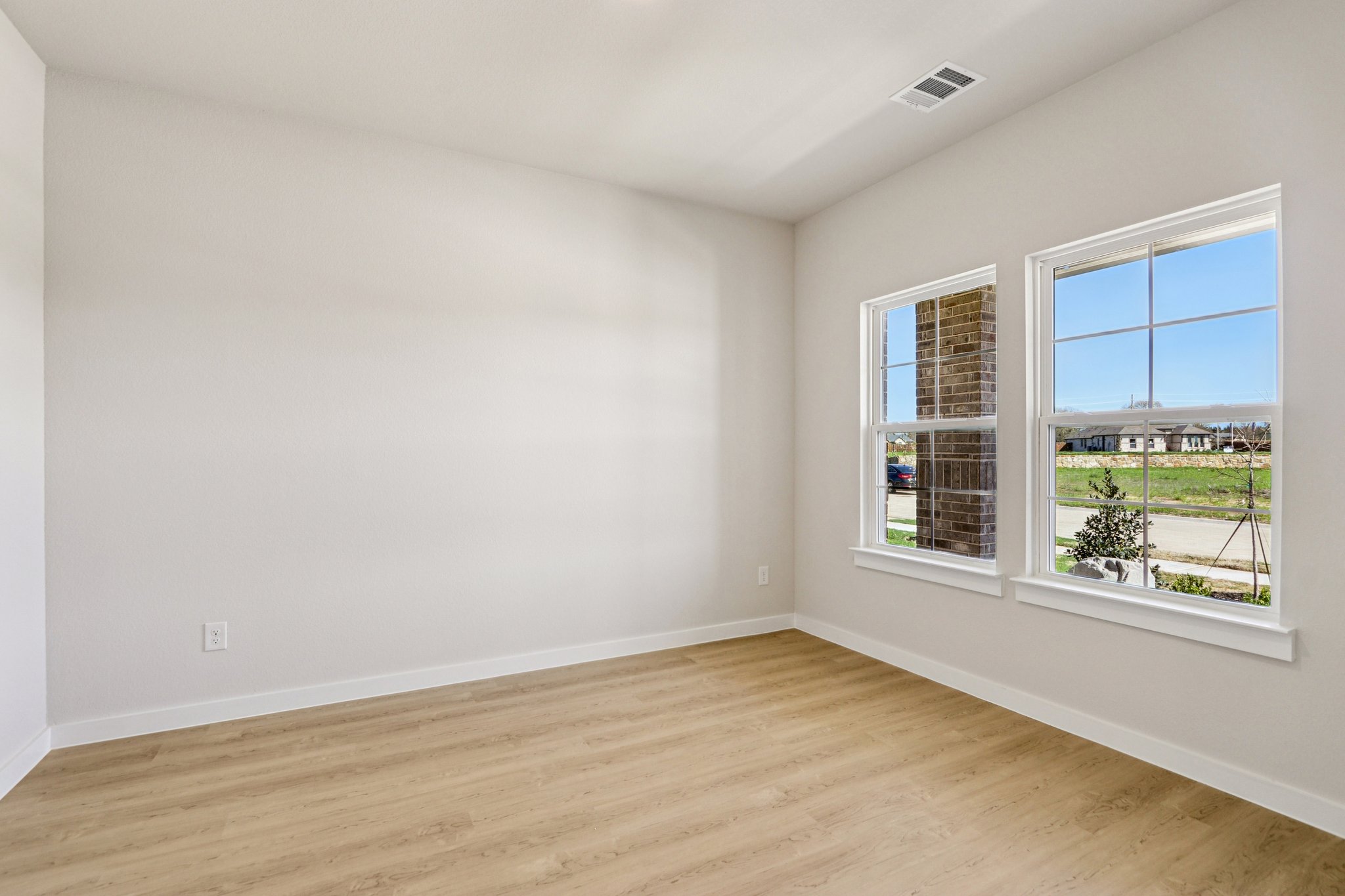 A room with windows and a wood floor.