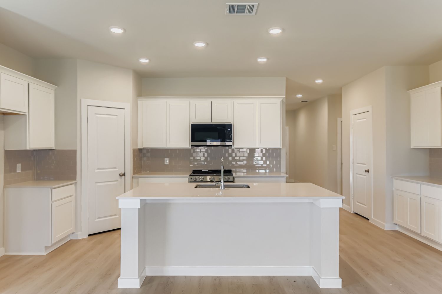 A kitchen with white cabinets.