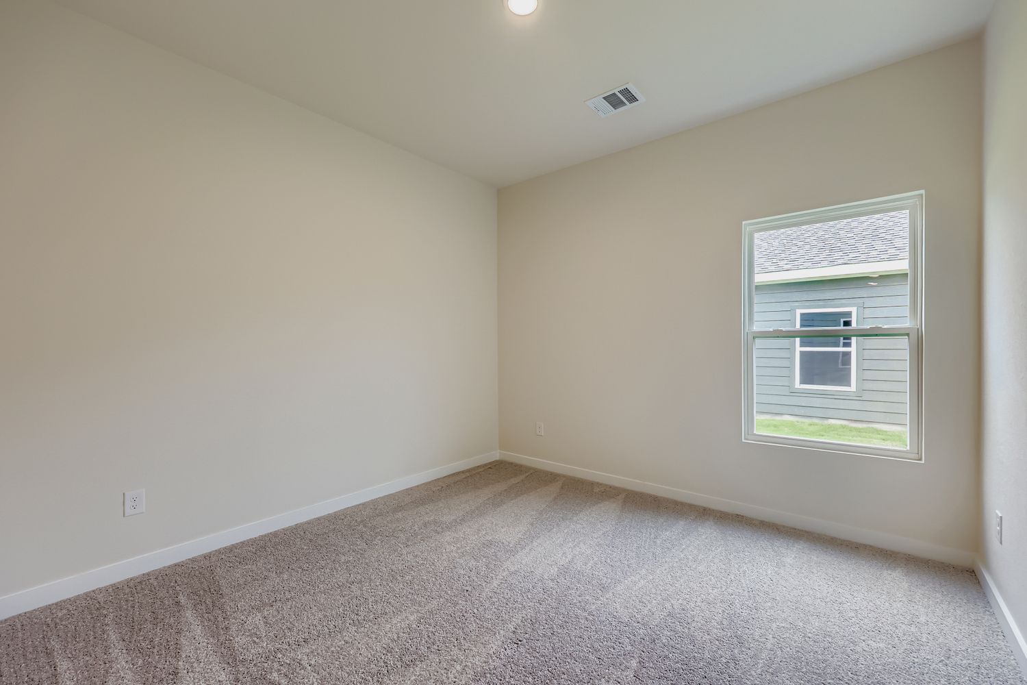 A room with a window and carpet.