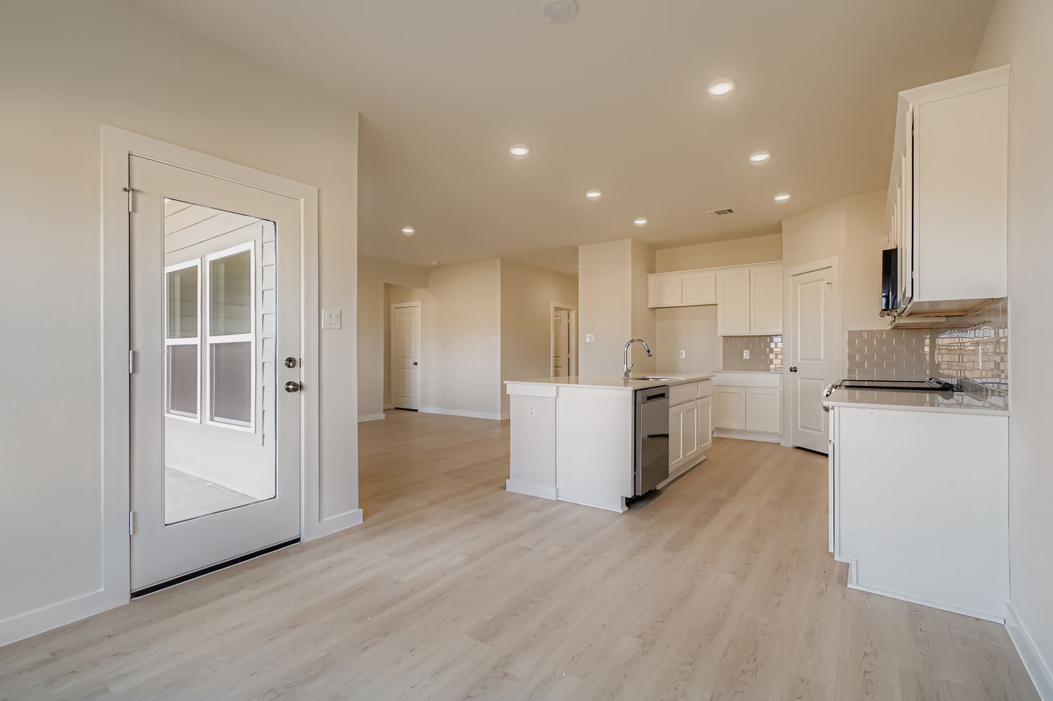 A kitchen with white cabinets.