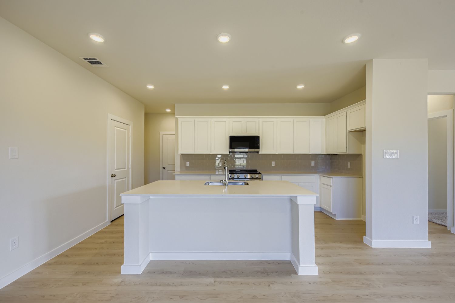 A kitchen with white cabinets.