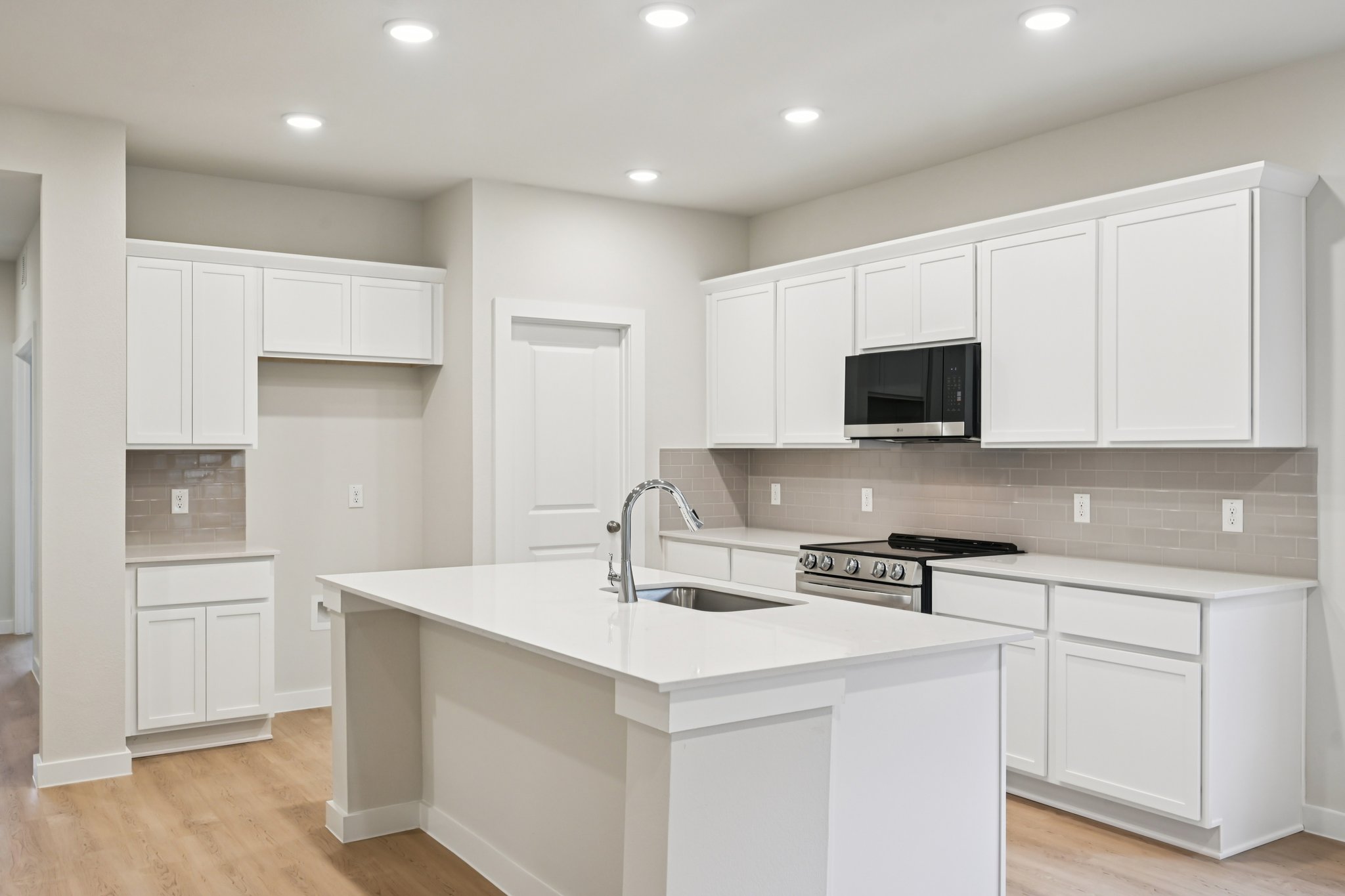 A kitchen with white cabinets.