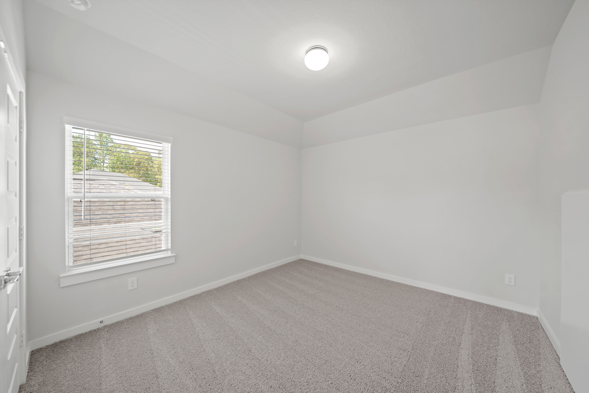 A room with a carpet and a window.