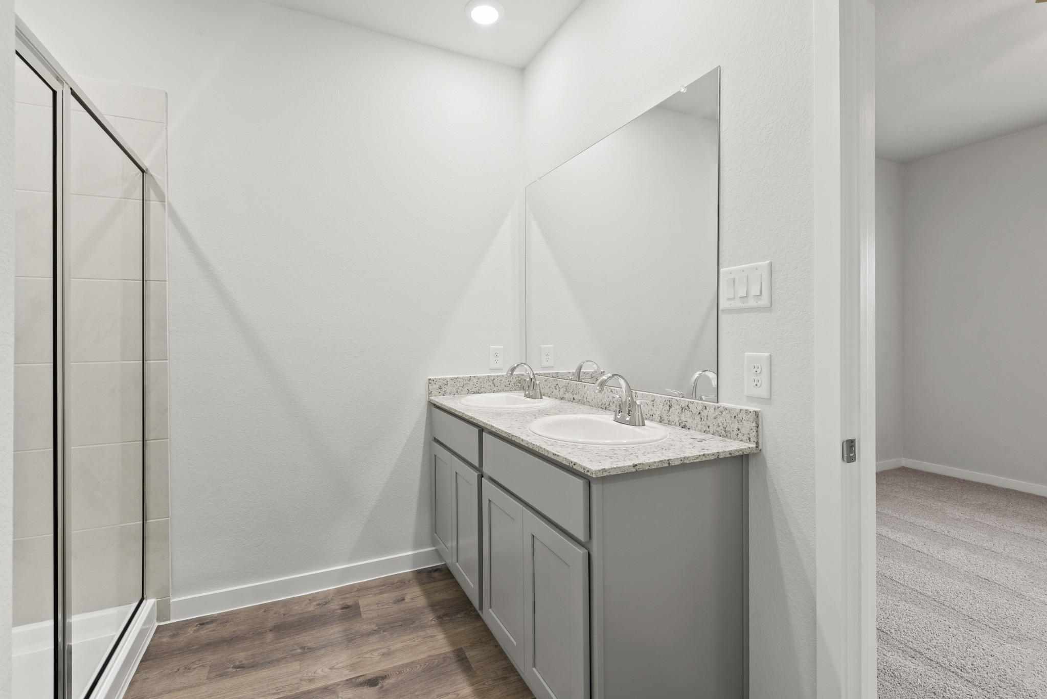 A bathroom with a sink and a shower unit.