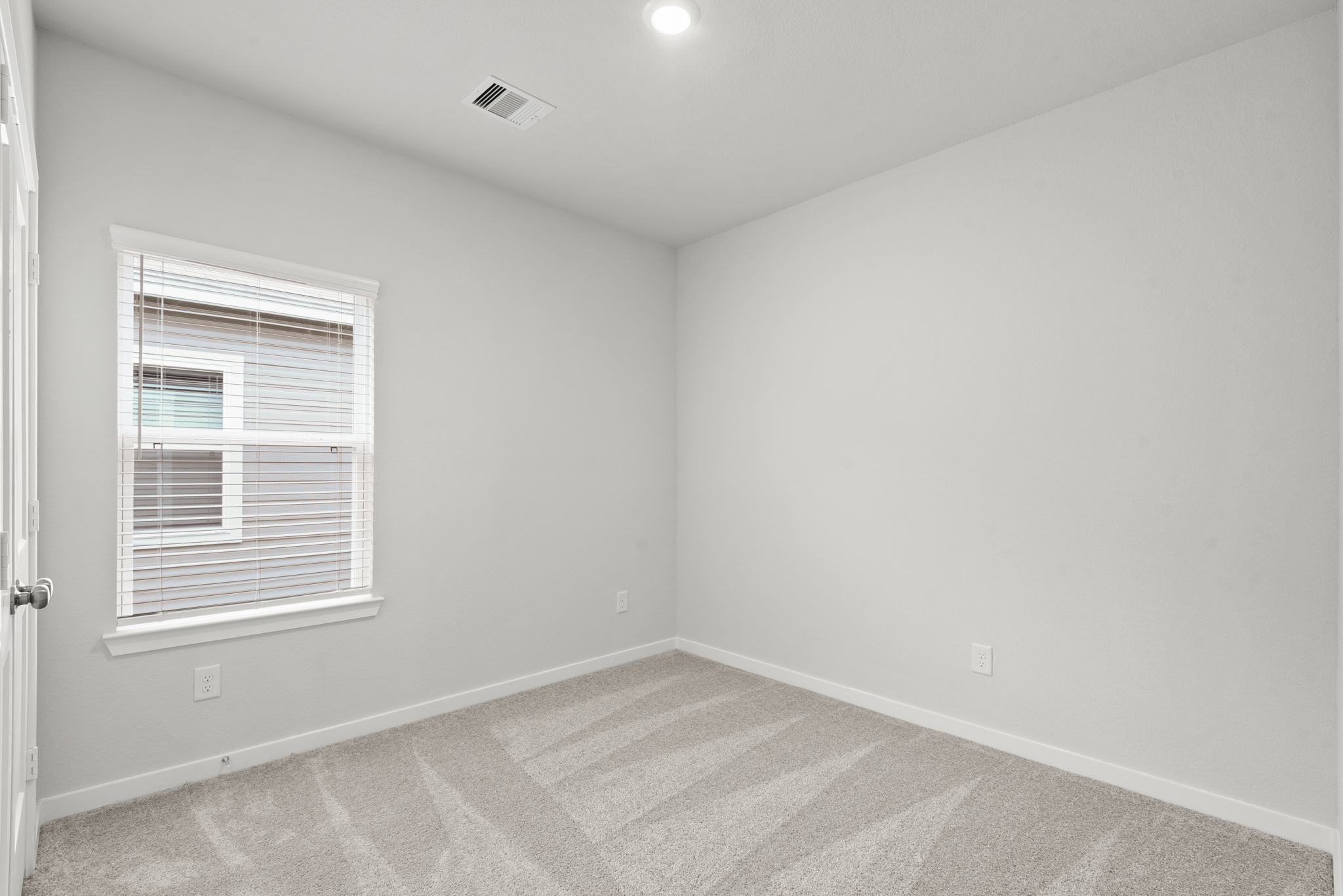 A room with a window and a rug.