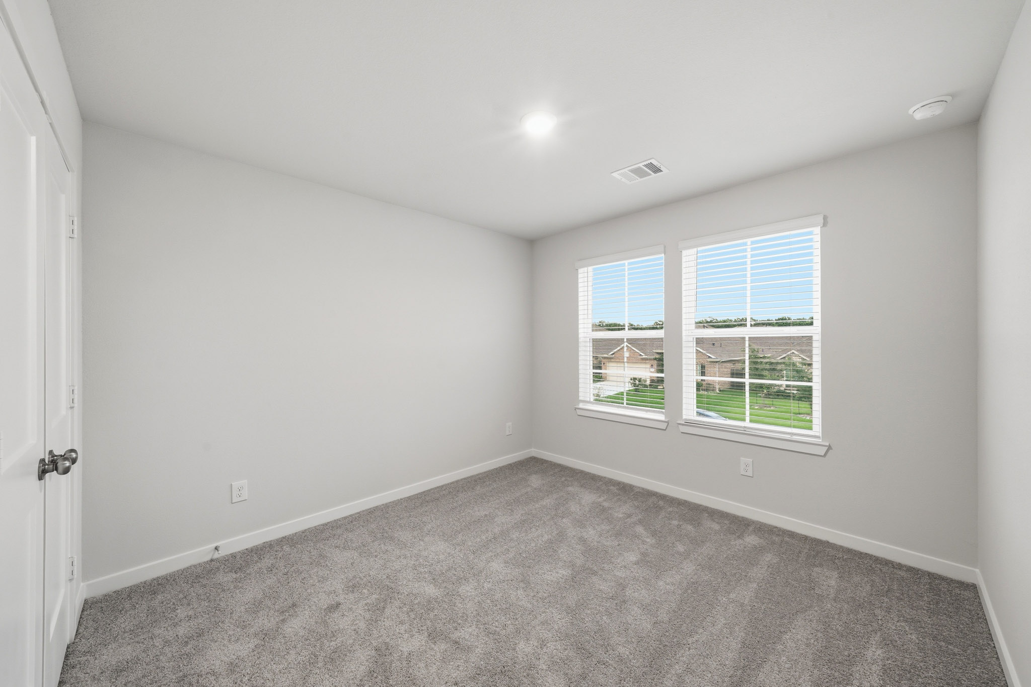 A room with a carpet and windows.