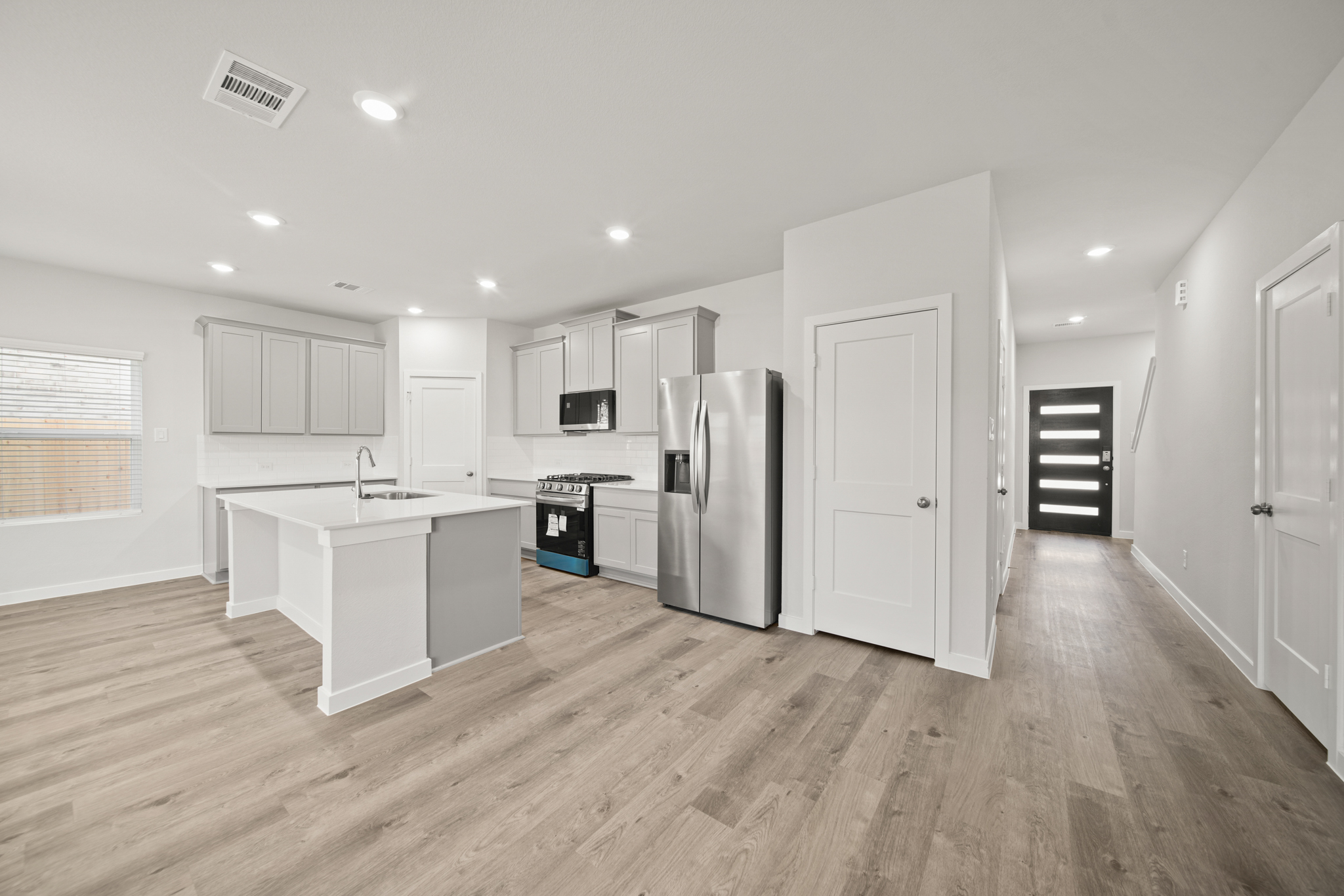 A kitchen with white cabinets.