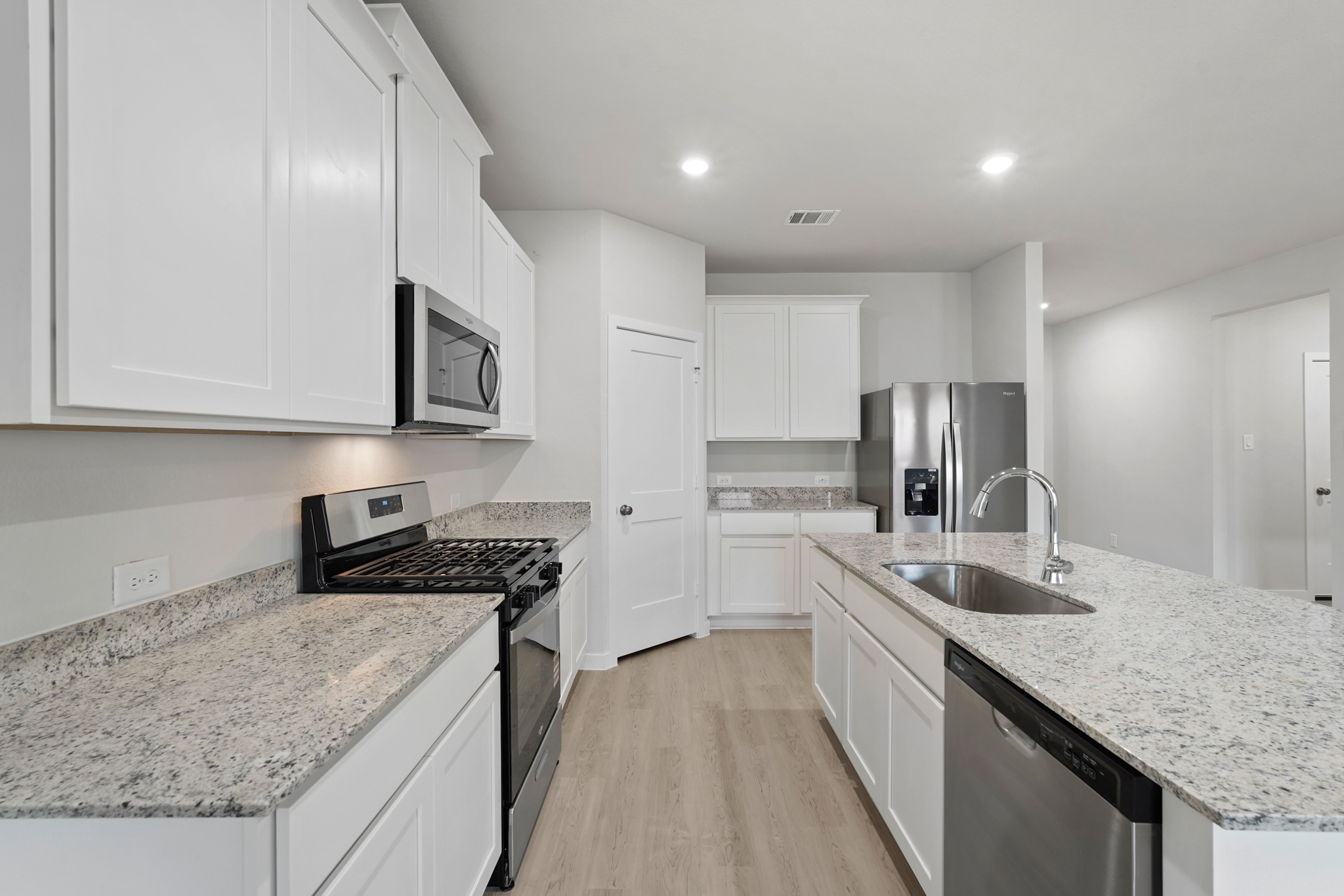 A kitchen with white cabinets.
