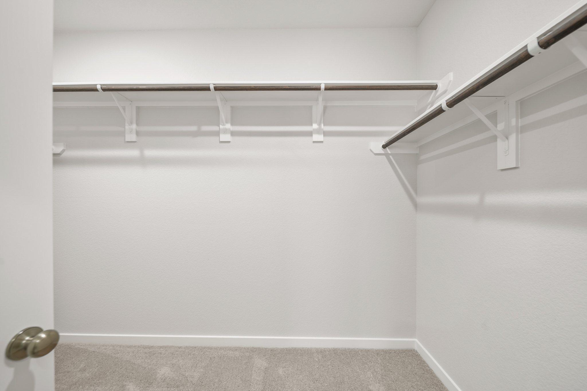 A white wall with a metal railing.