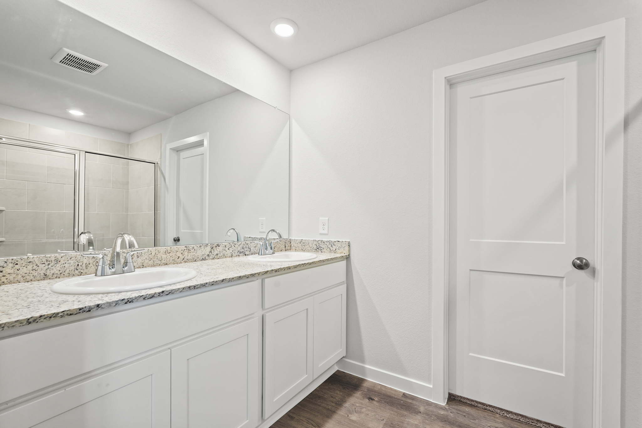 A bathroom with a large mirror.