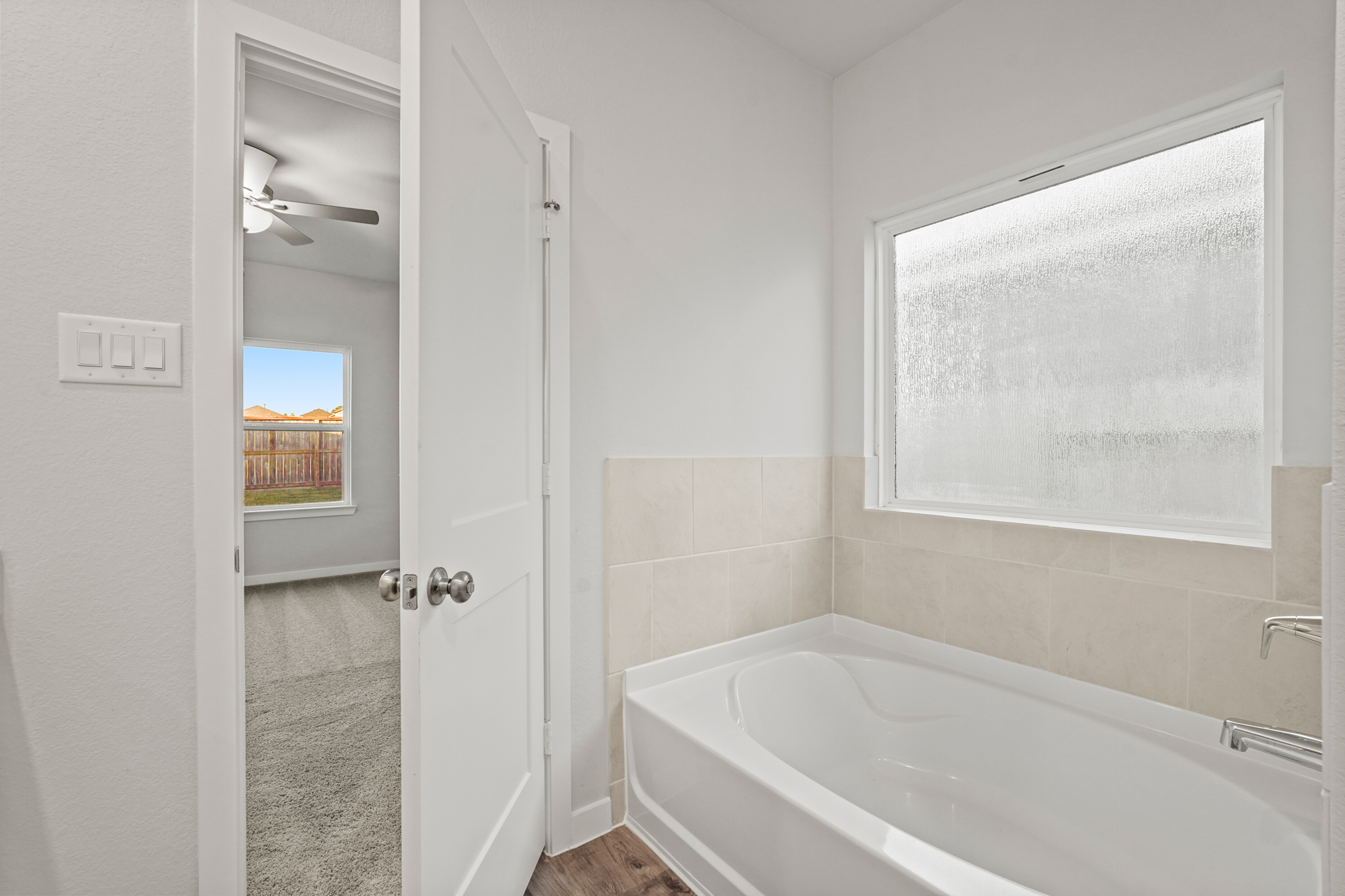 A bathroom with a bathtub and a window.