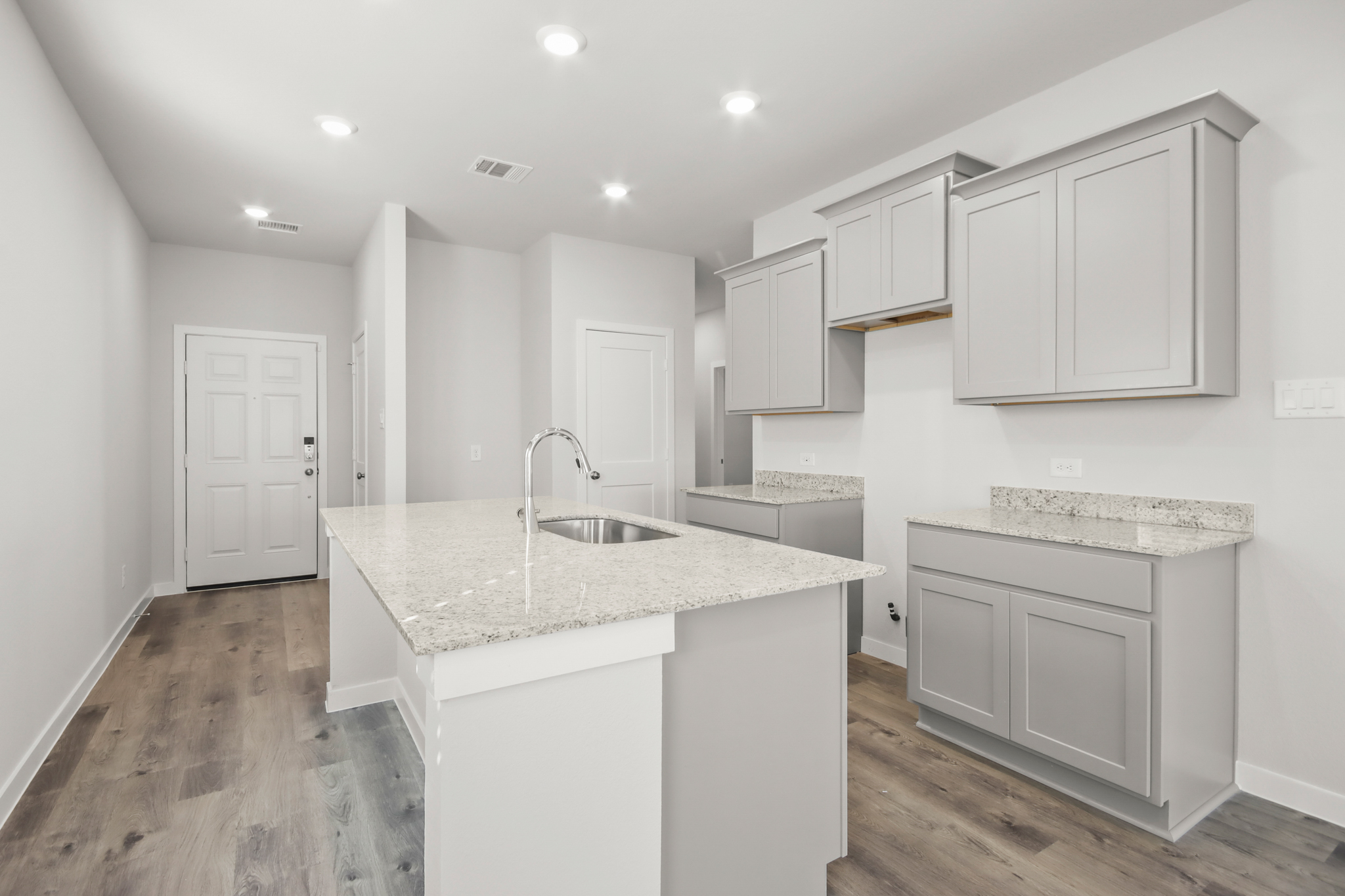 A kitchen with white cabinets.
