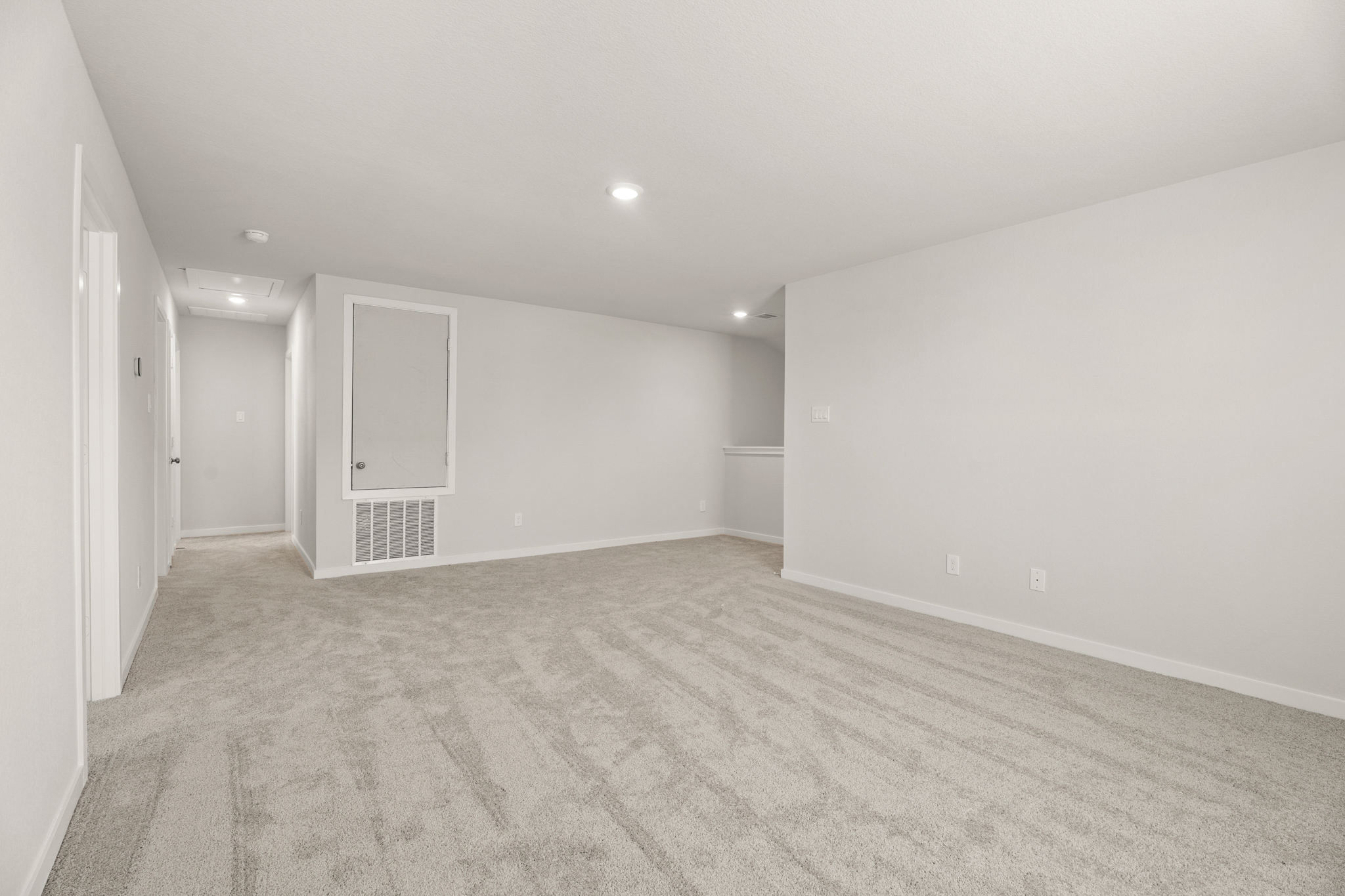 A room with a carpet and a door.