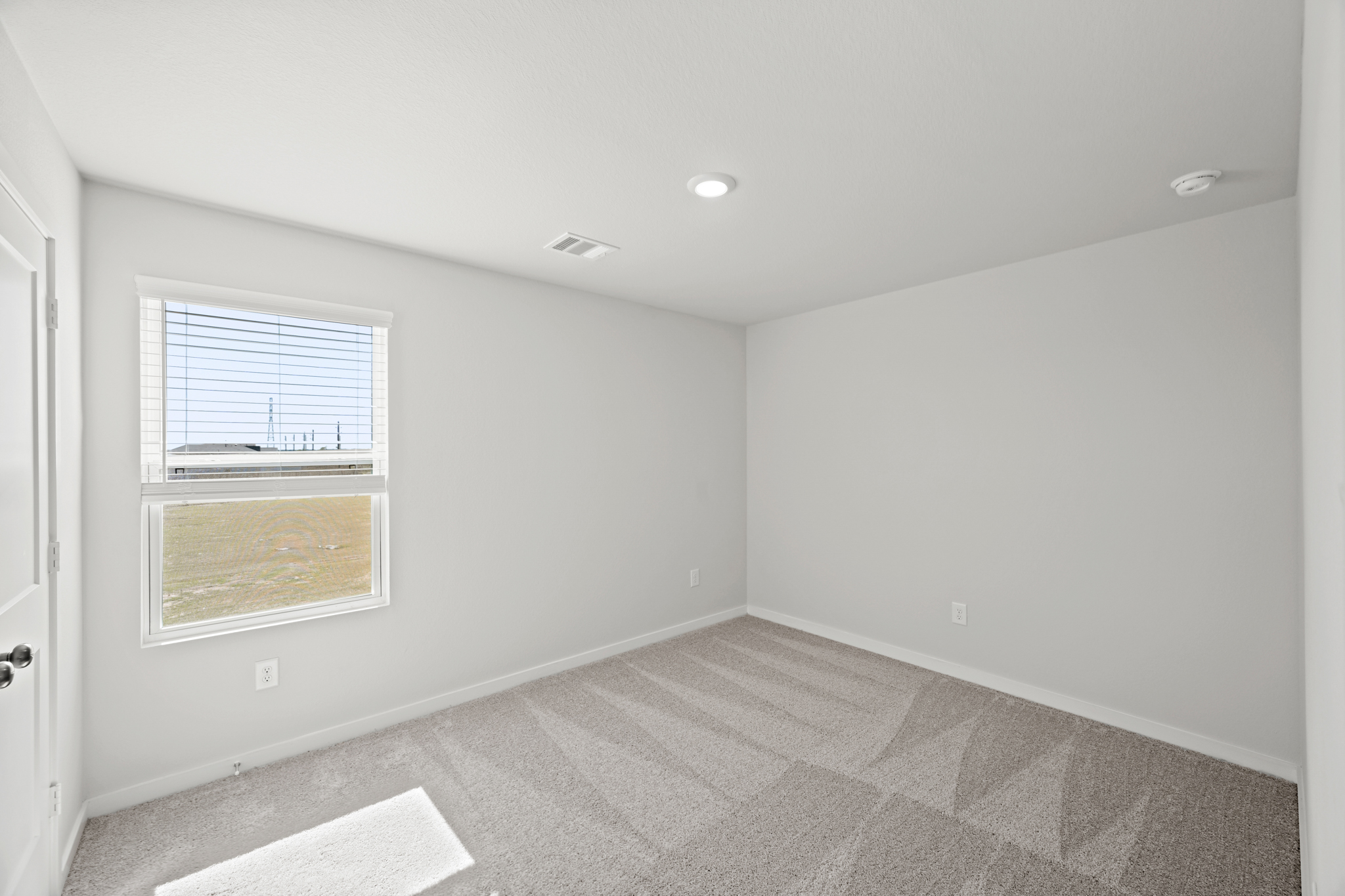 A room with a carpet and a window.