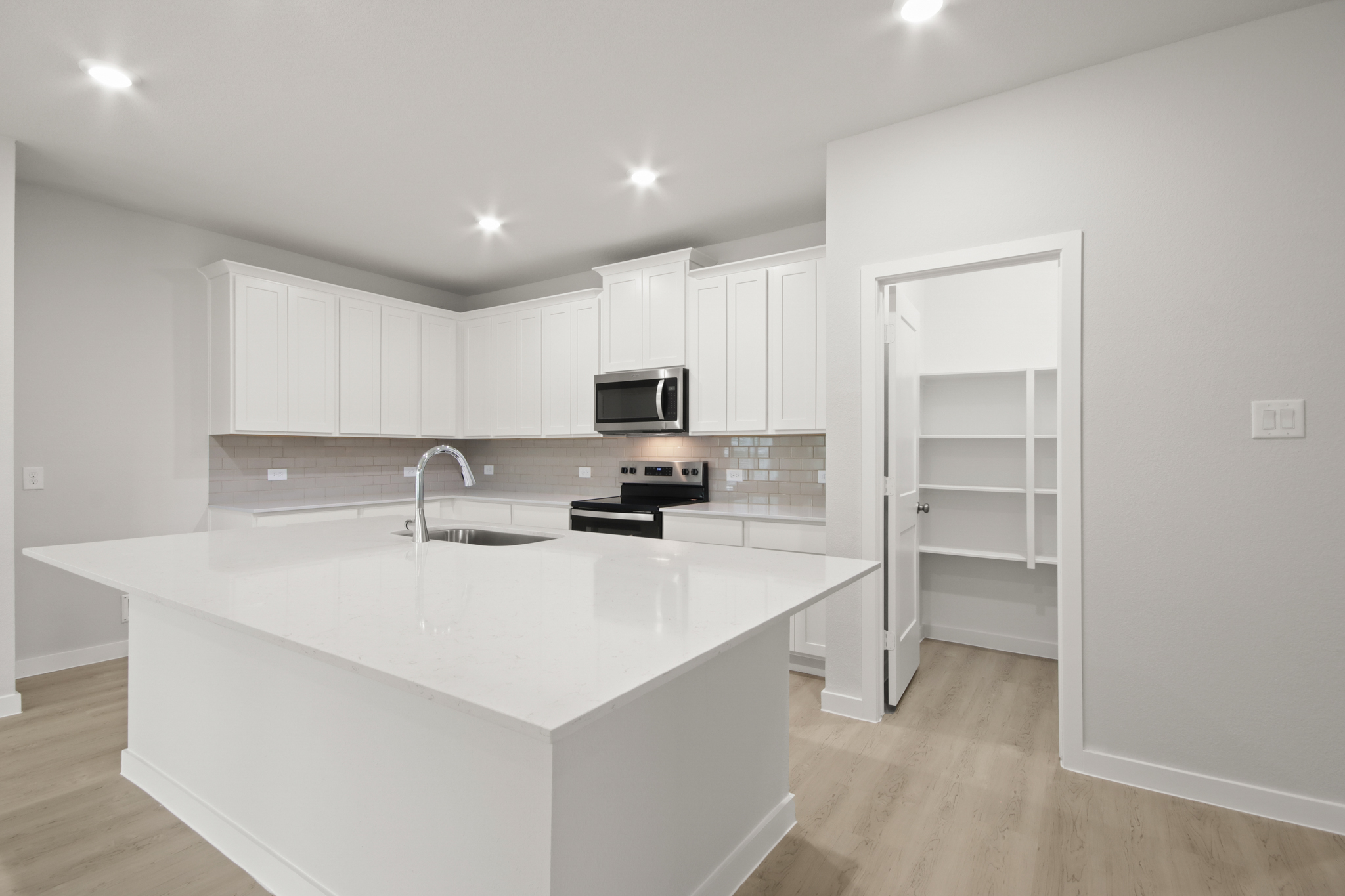 A kitchen with white cabinets.