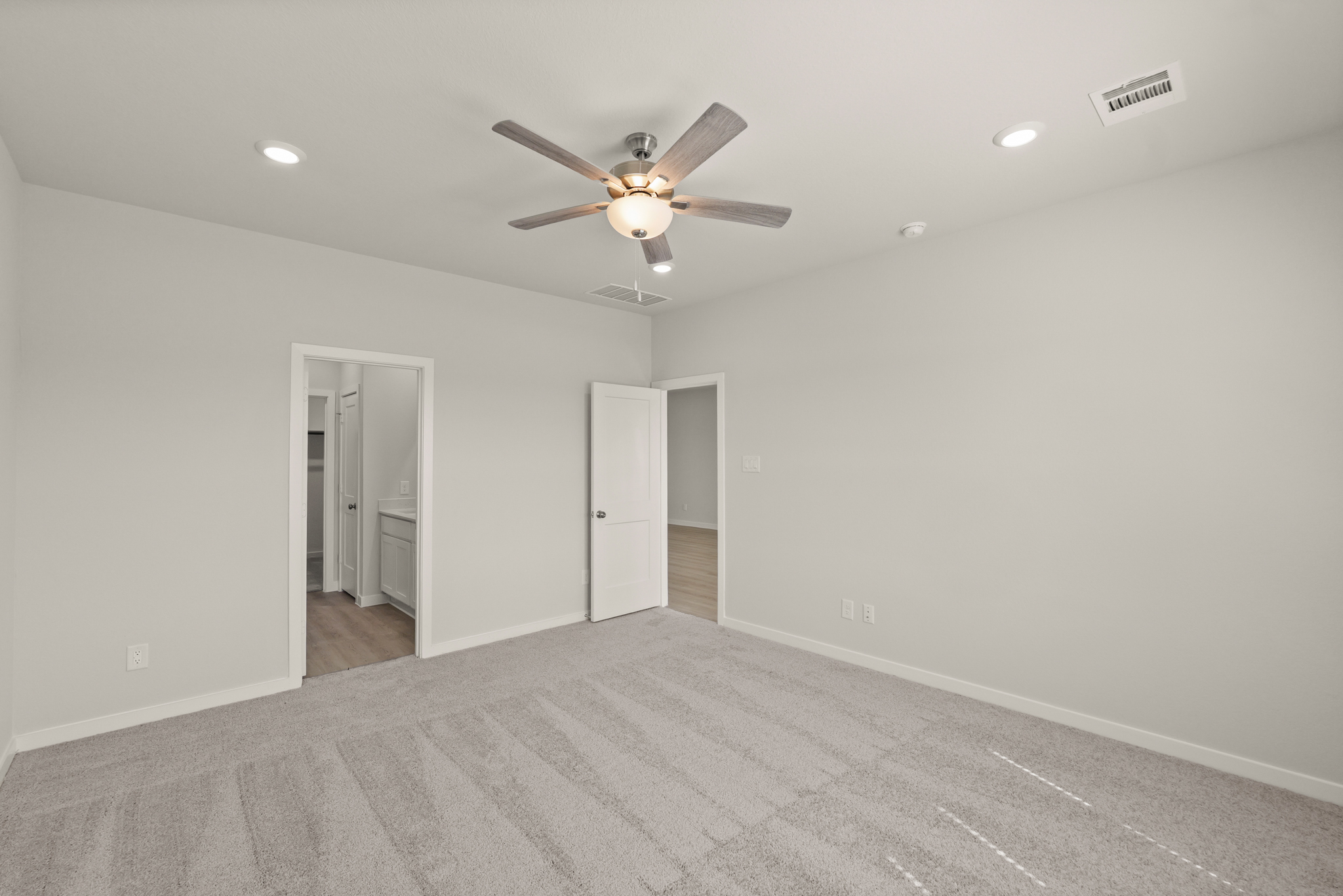 A room with a ceiling fan and a door.