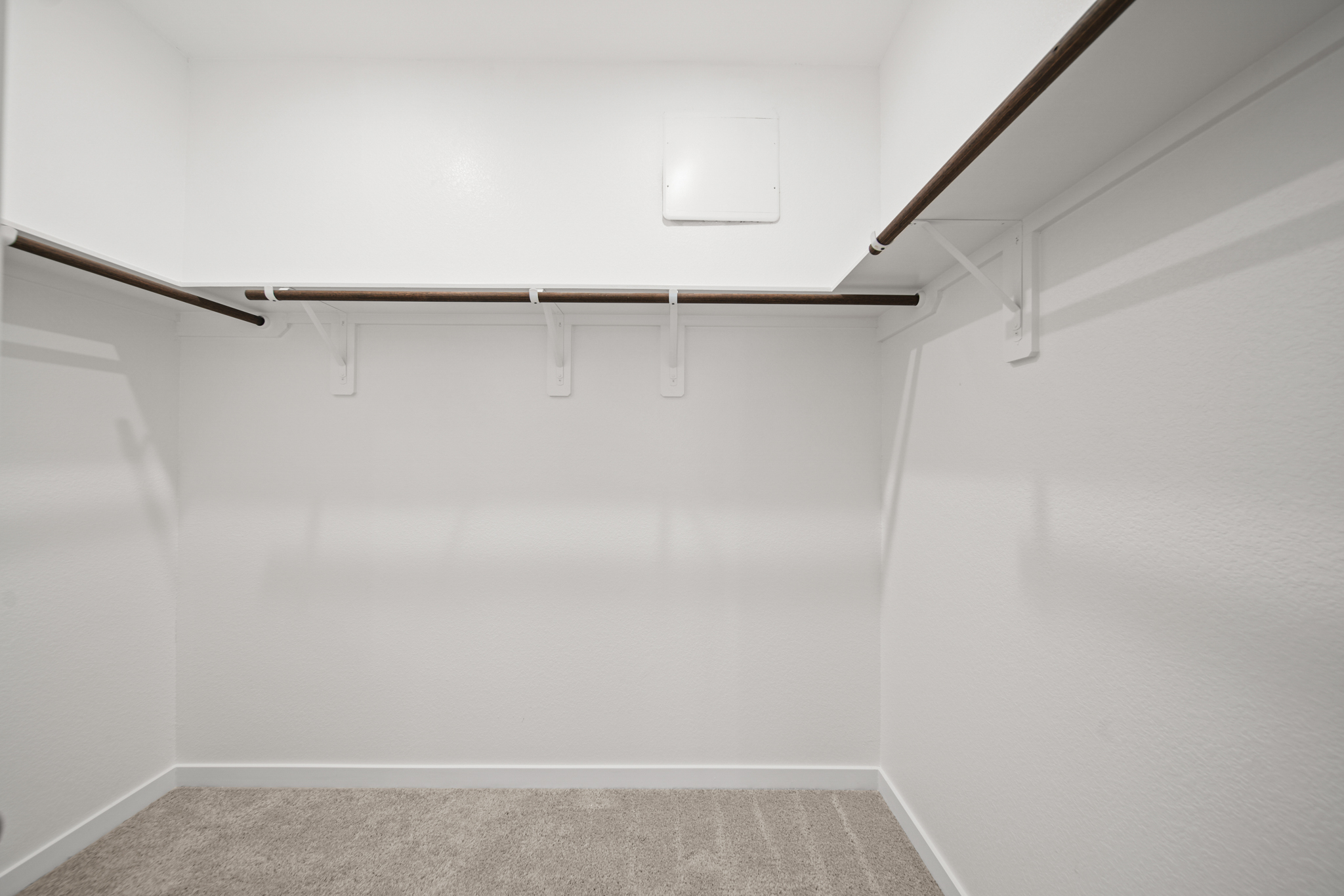 A white wall with a metal bar.