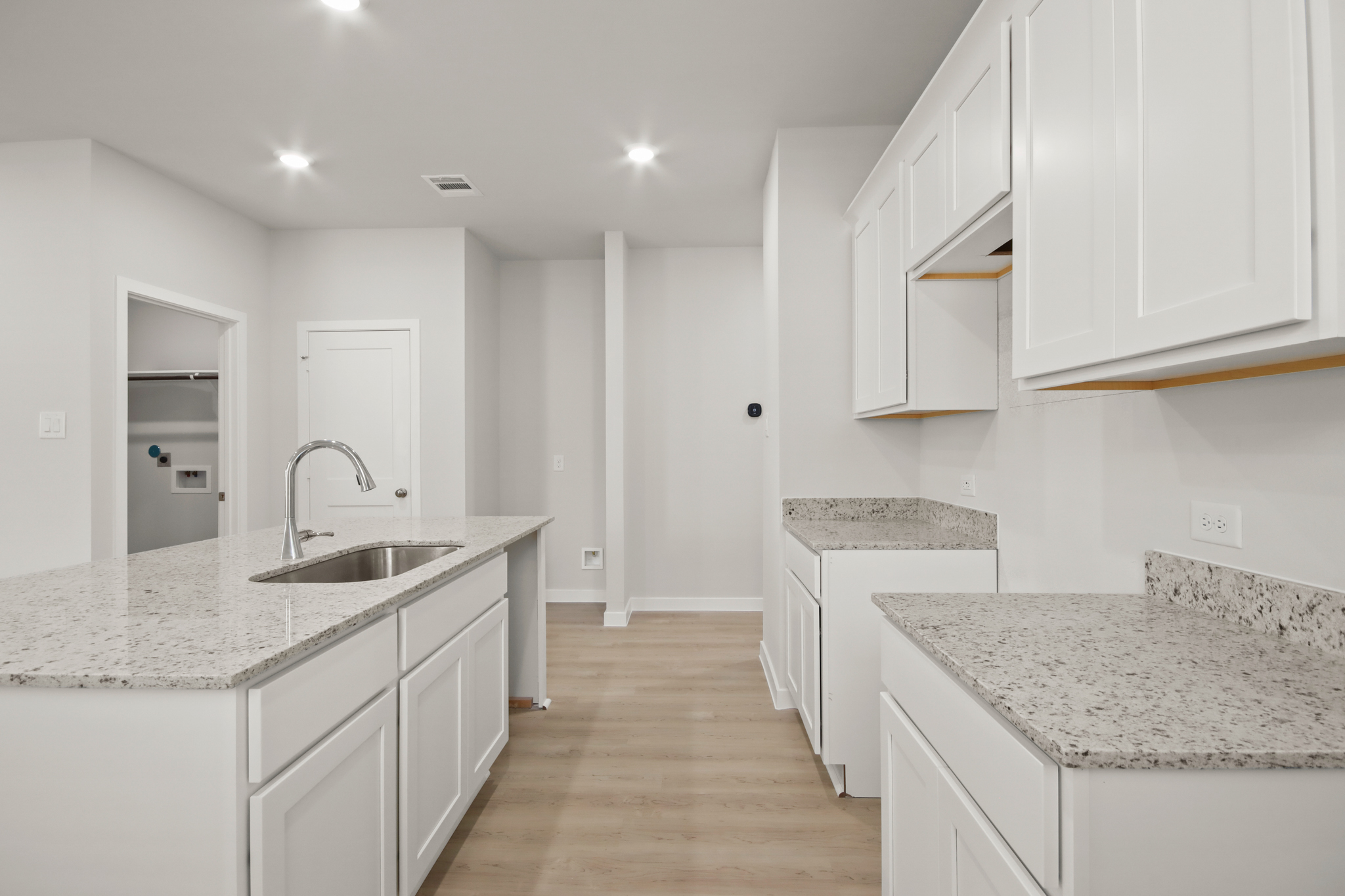 A kitchen with white cabinets.