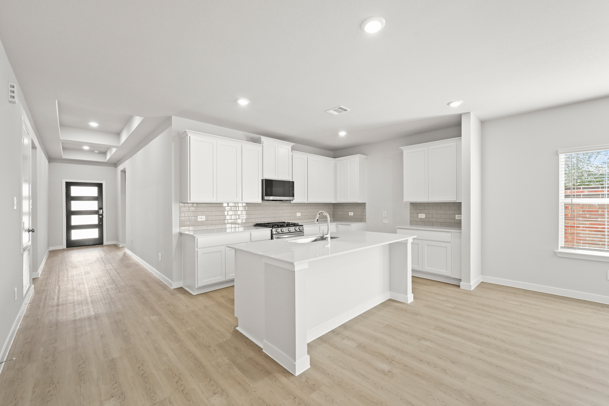 A kitchen with white cabinets.