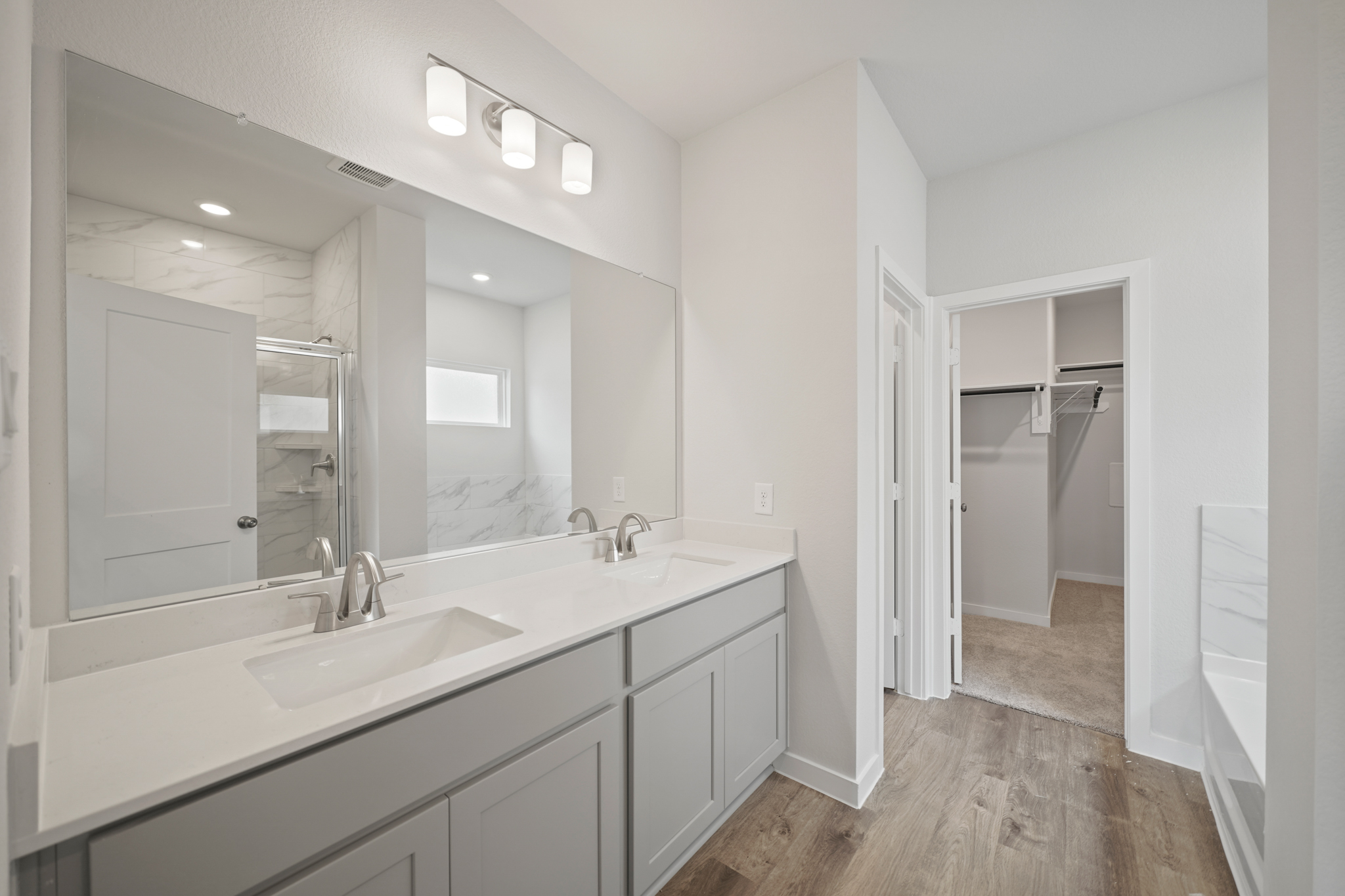 A bathroom with white cabinets.