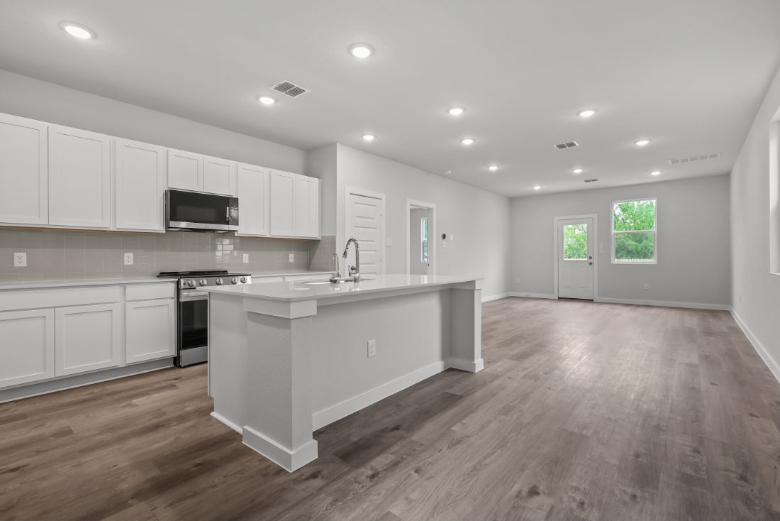 A kitchen with white cabinets.