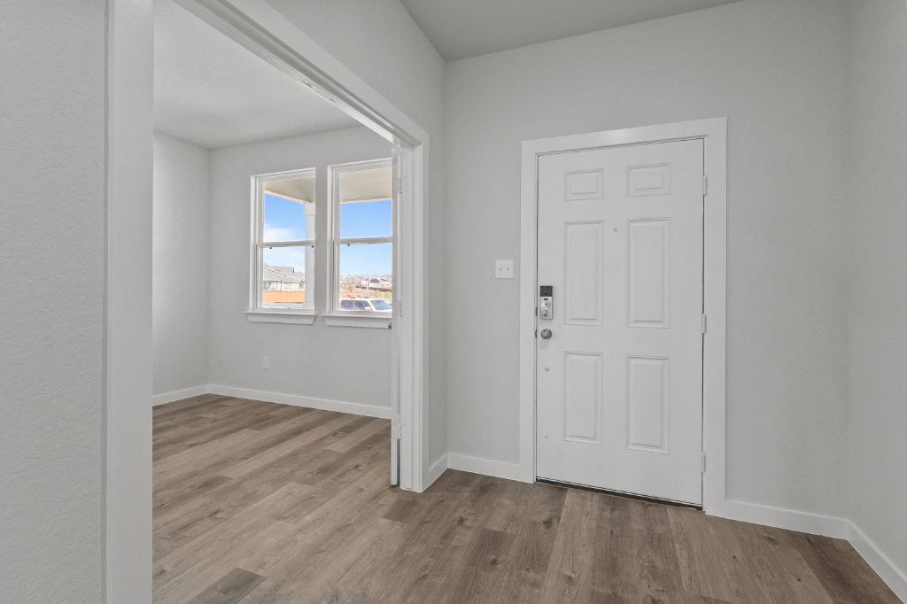 A room with a white door and a window.