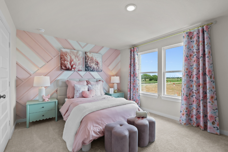 A bedroom with a pink bed and pink curtains.
