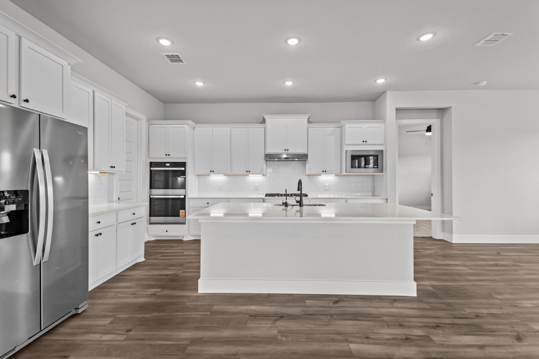 A kitchen with white cabinets.