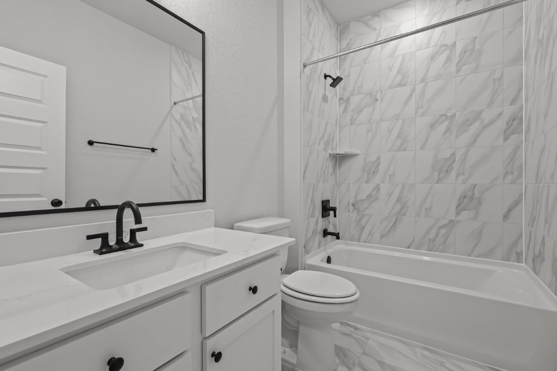 A bathroom with a sink toilet and bathtub.