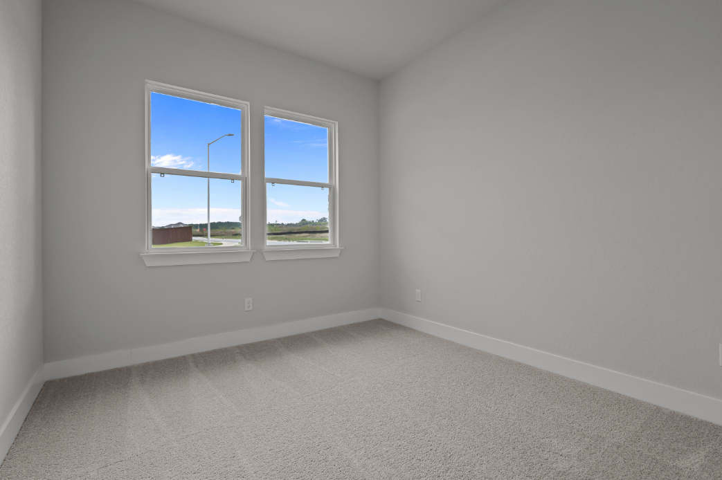 A room with a window and a carpet.
