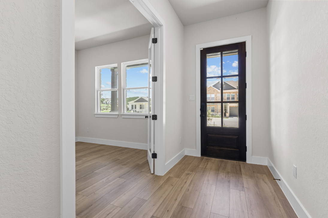 A room with a wood floor and a door with a window.