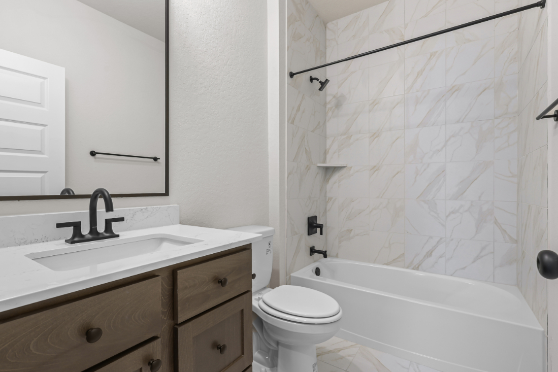 A bathroom with a tub sink and toilet.