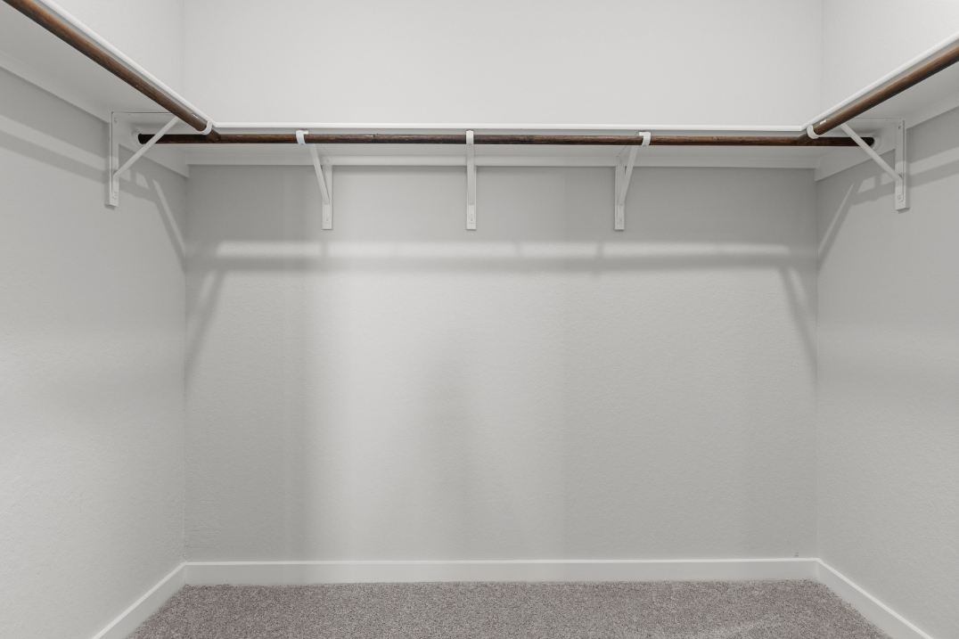 A white wall with a metal bar.