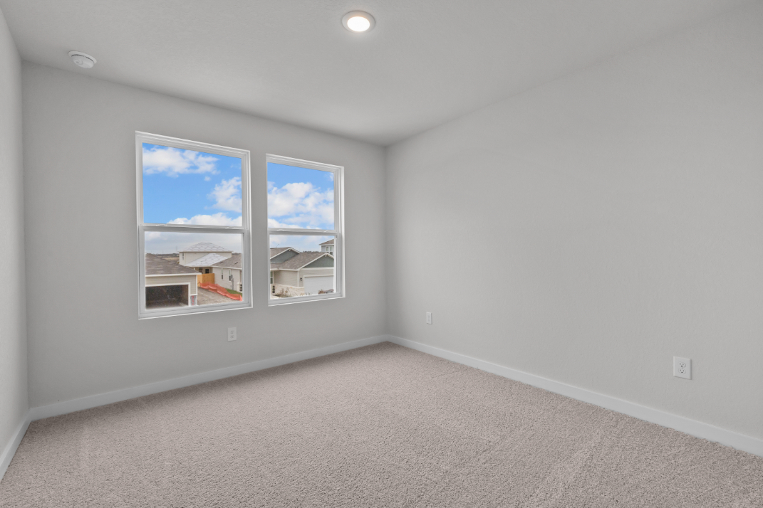 A room with a window and a painting on the wall.