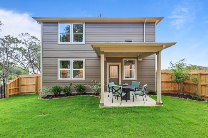 A house with a table and chairs in the front.
