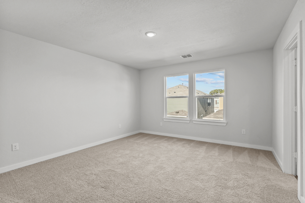 A room with a window and a carpet.