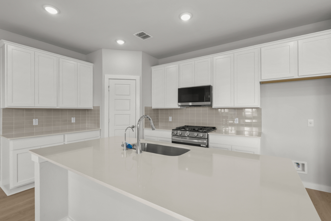 A kitchen with white cabinets.