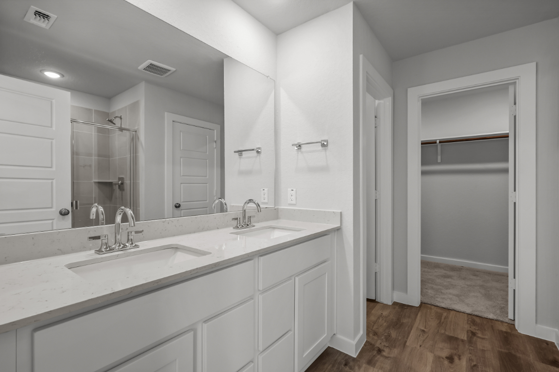 A bathroom with white cabinets.