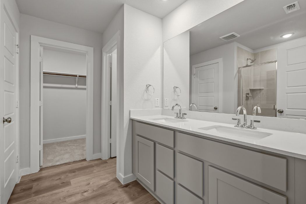 A bathroom with white cabinets.