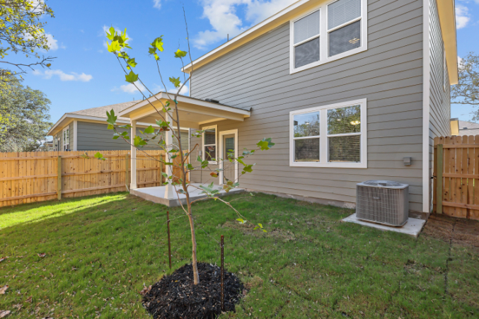 A house with a tree in the front yard.