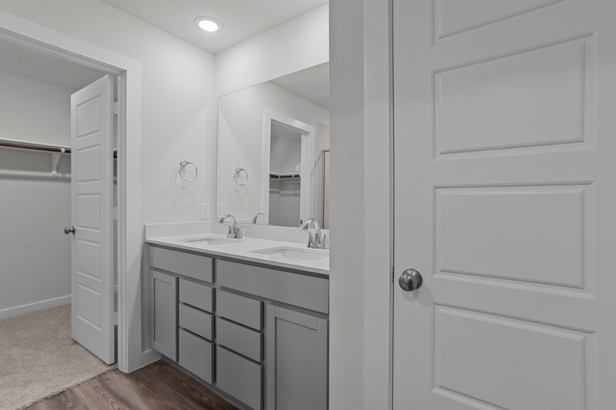 A bathroom with white cabinets.