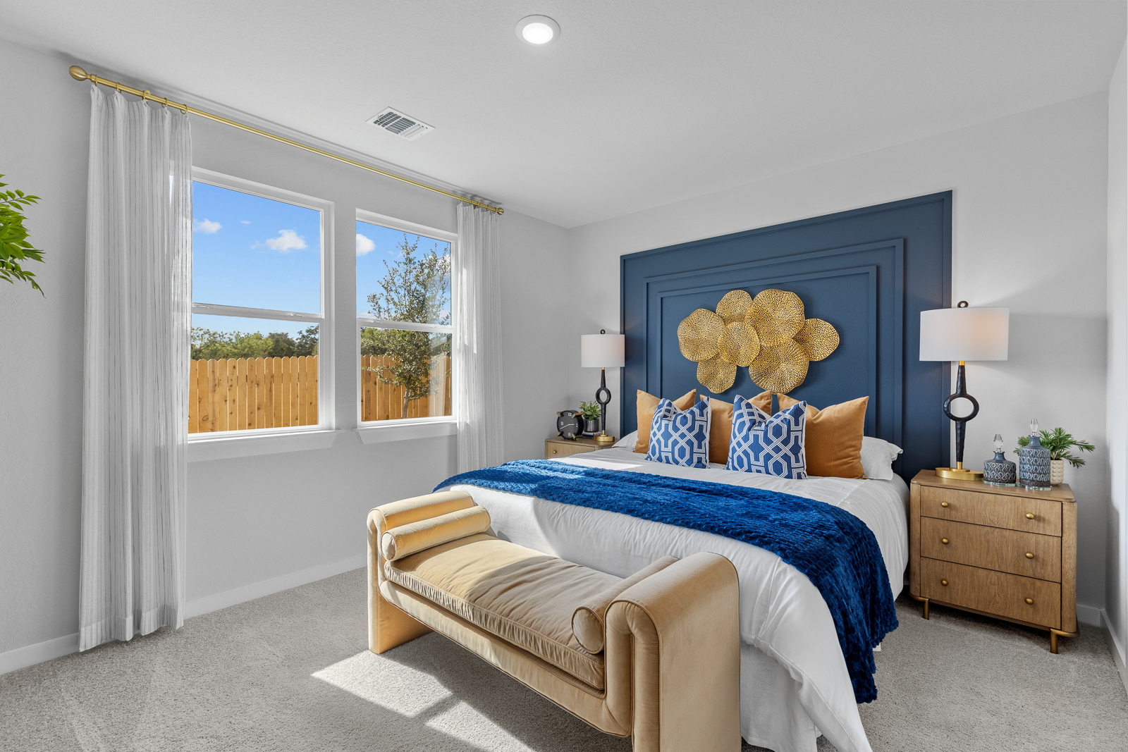 A bedroom with a bed and a bench.