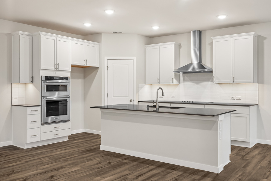 A kitchen with white cabinets.