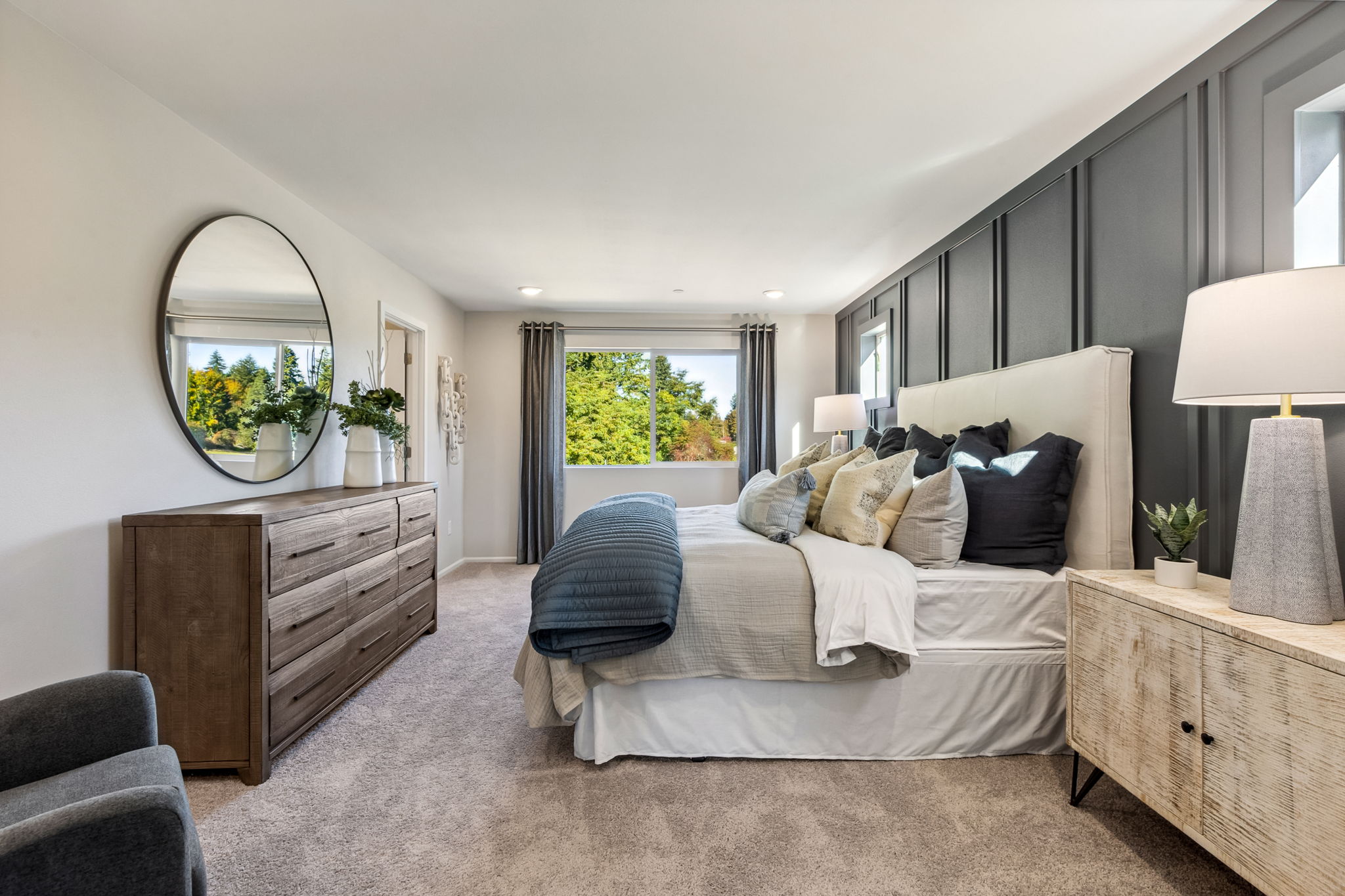 A bedroom with a bed and a mirror.