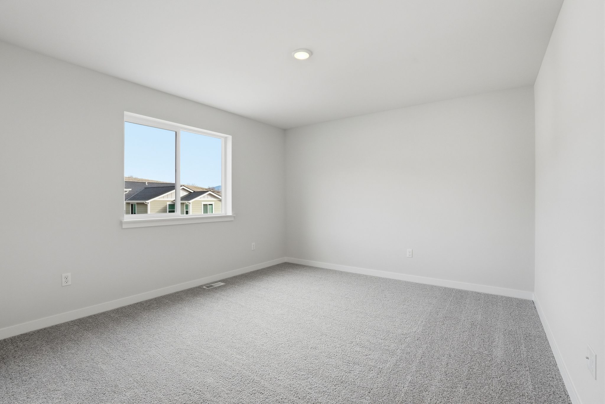 A room with a window and a carpet.